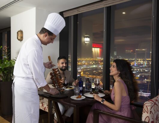 Chef serving a couple tableside at Park Regis Kris Kin's Kris with a View