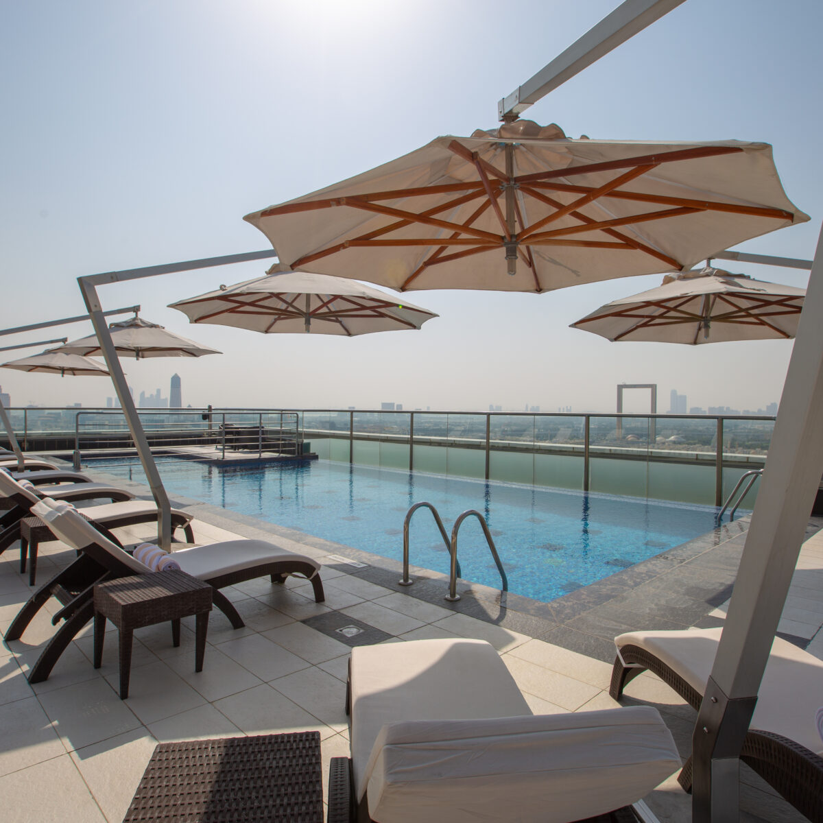 Park Regis Kris Kin Rooftop Pool with umbrellas and lounge chairs