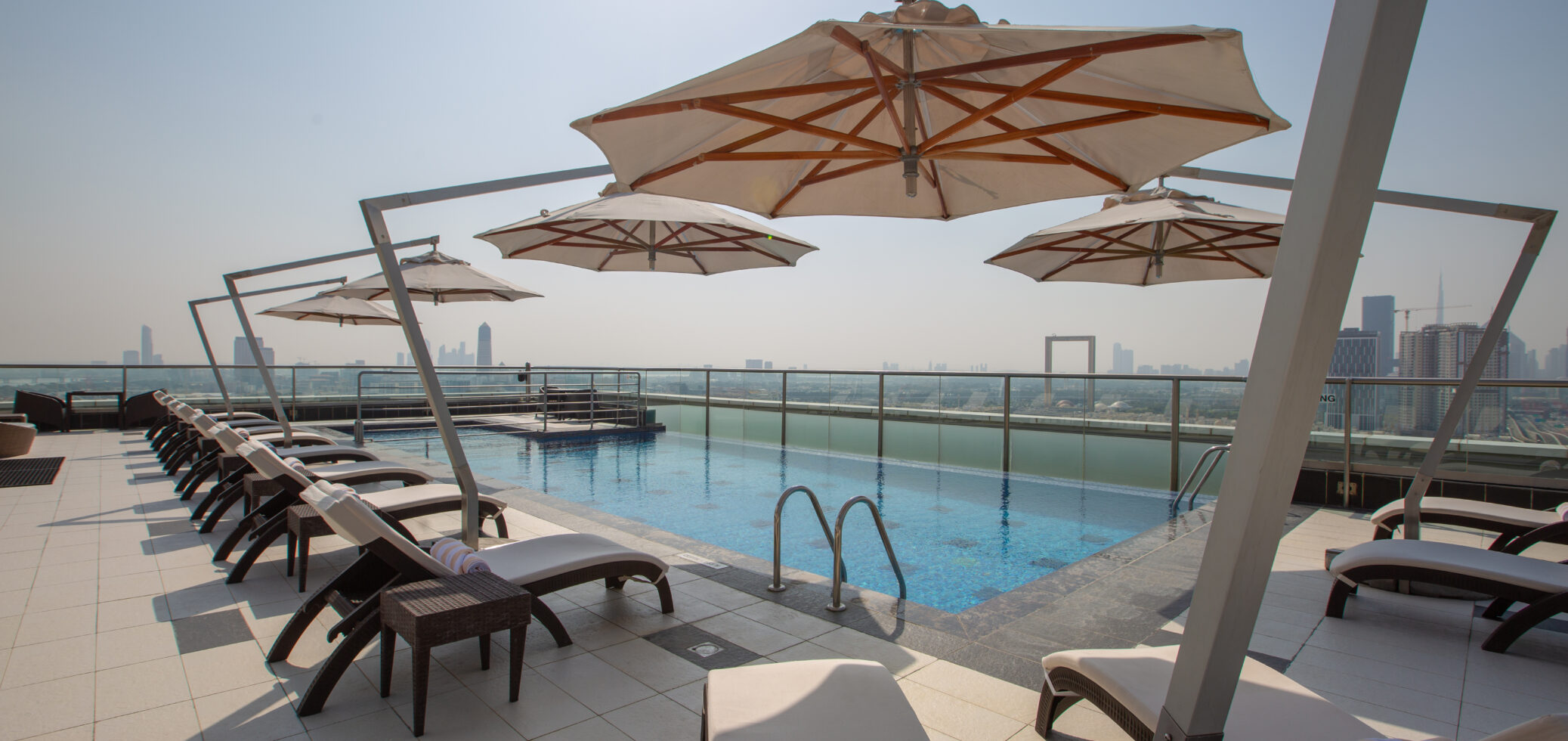 Park Regis Kris Kin Rooftop Pool with umbrellas and lounge chairs